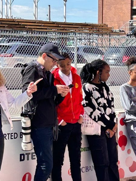 Adult and children looking at a phone outdoors.