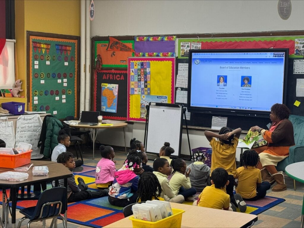 Adult reads to children on a rug in a classroom.