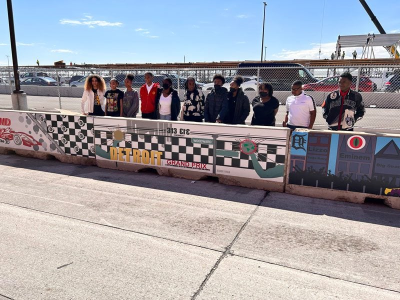 Children standing behind a painted concrete barrier.